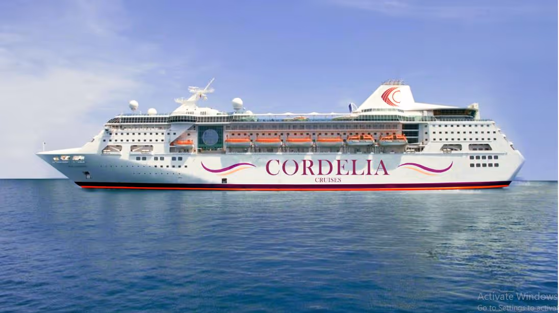 Large white cruise ship labeled Cordelia Cruises sailing on calm blue ocean under a clear sky.